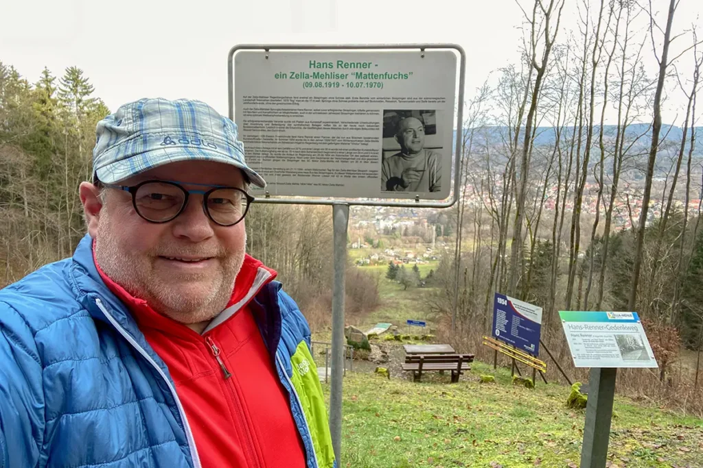 Selfie: Torsten Widder im Wald im Hintergrund Schild mit Hinweis zum Hans-Renner-Gedenkweg Zella-Mehlis